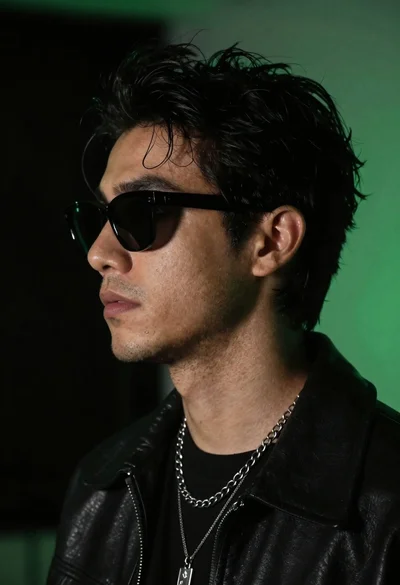 Close up profile portrait of young man in black jacket against dark