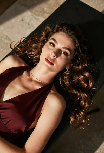 High angle portrait of woman with brown hair on dark surface