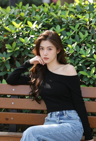 Young woman with brown hair sitting on bench near green bushes outdoors
