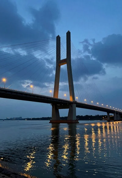 Low angle view of modern cablestayed bridge spanning wide river at twilight