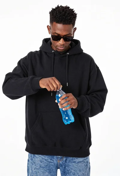 Young man opening blue sports drink on white background