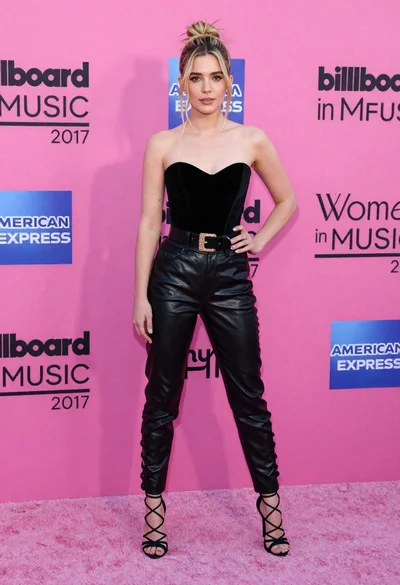 Blonde woman in black leather bodysuit on a bright pink red carpet