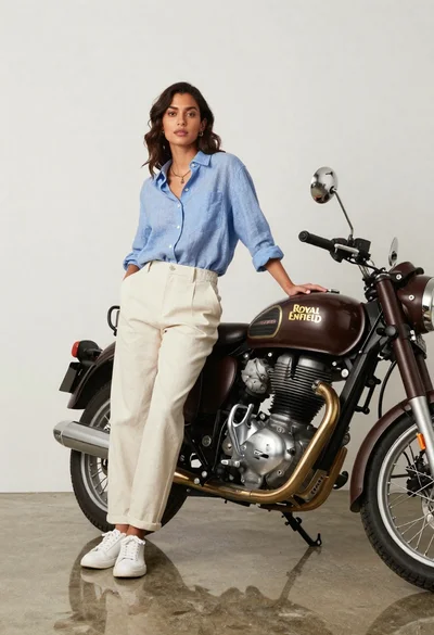 Stylish woman posing next to vintage motorcycle in minimalist studio