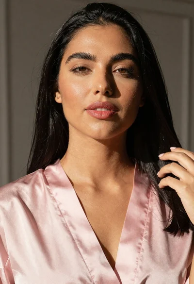 Studio portrait of woman in pink satin robe