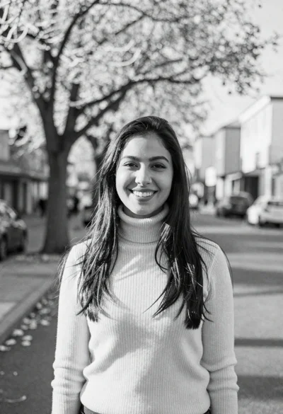 Smiling young woman in ribbed turtleneck against snowy urban street bokeh