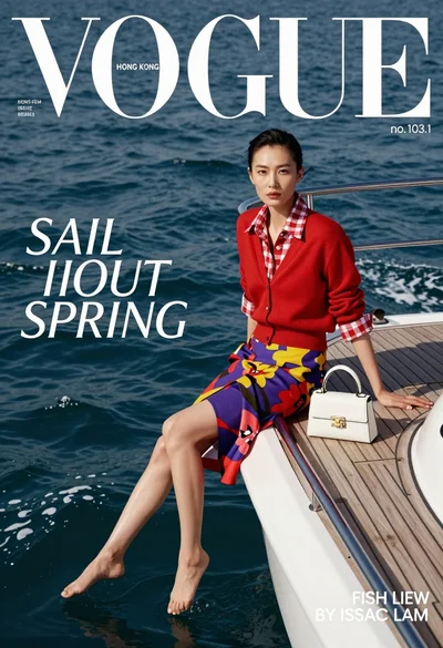 High fashion magazine cover of east asian woman on yacht overlooking blue
