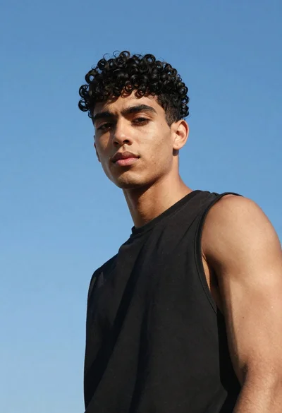 Young man in black shirt against clear blue sky