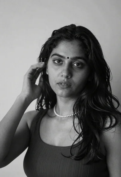 Black and white portrait of woman with dark hair touching temple