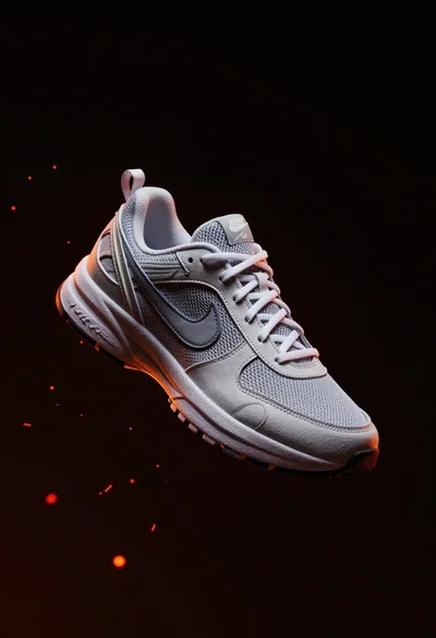 Nike sneaker floating in dark void with embers
