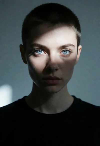 Close up portrait of person with blue eyes under dramatic spotlighting