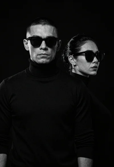 High contrast black and white studio portrait of muscular man and woman