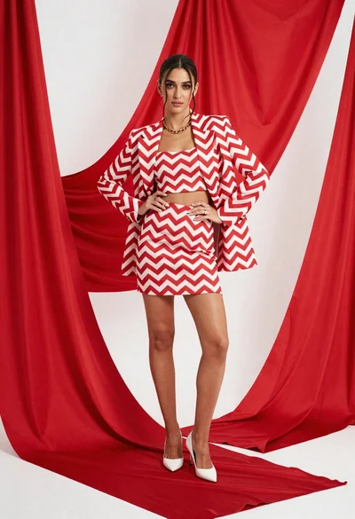 Young woman in red chevron outfit posing in bright studio setting