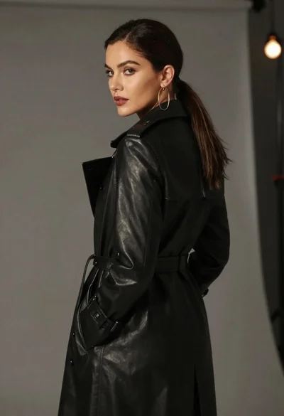 Woman in black trench coat looking over shoulder