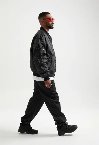 Man walking in profile looking back against white studio background