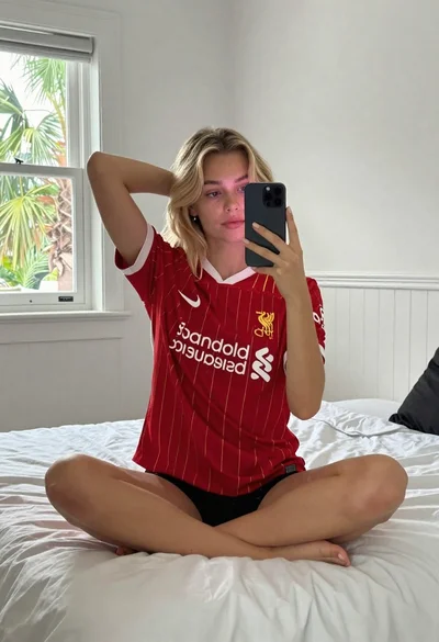 Fair skinned young woman with wavy blonde hair taking a mirror selfie