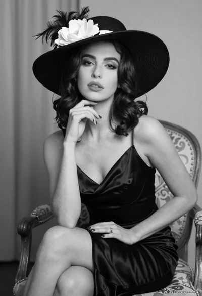 Medium close up of woman in black satin dress with feathered hat