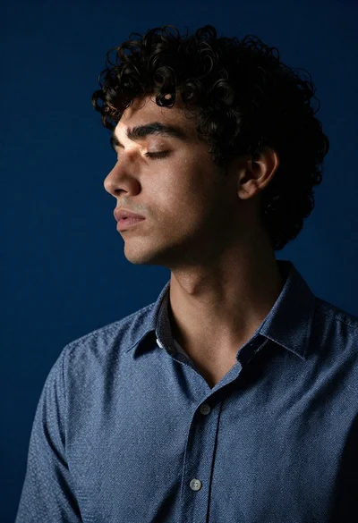 Profile portrait of young man with dark curly hair
