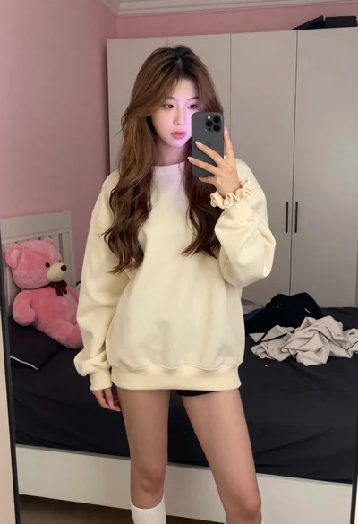 Young woman taking mirror selfie in bedroom with teddy bear