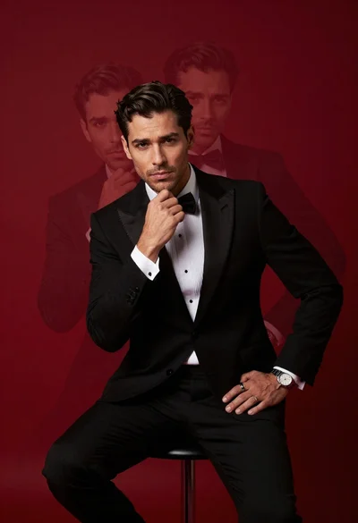 Confident man in black tuxedo sitting on stool with ghostly face overlays