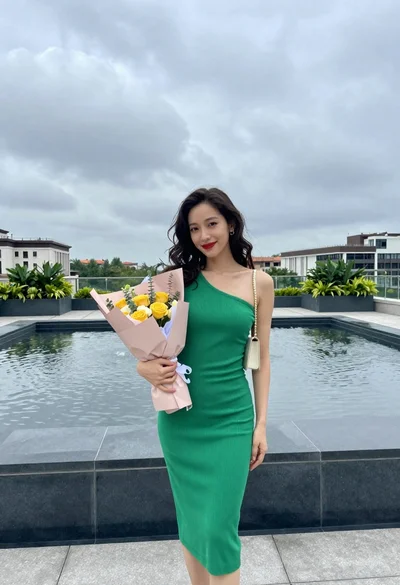 Young woman in green dress on rooftop by water feature under cloudy