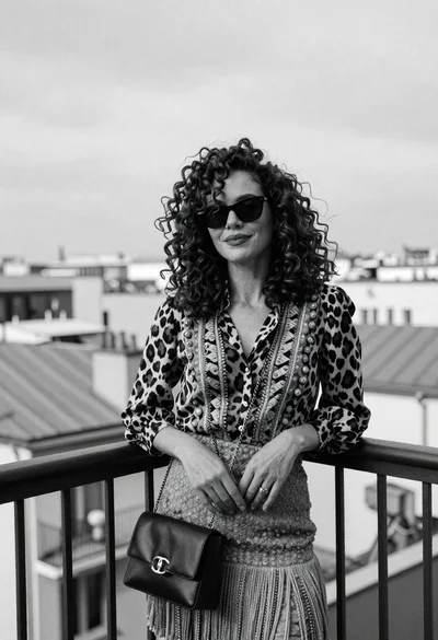 Stylish woman on balcony overlooking city skyline in high contrast black and
