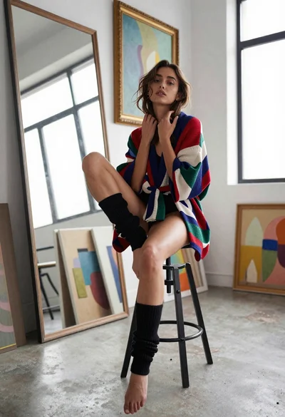 Young woman in kimono cardigan posing in bright art studio setting