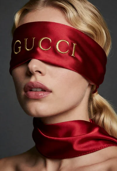 Close up portrait of blonde woman wearing red silk blindfold studio shot