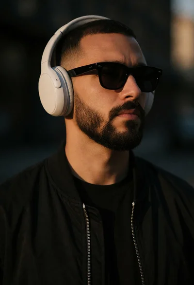 Close up portrait of man in black jacket with headphones at dusk