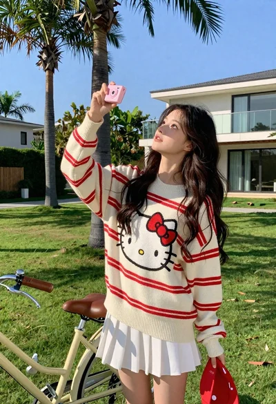 Young woman in oversized sweater holding pink camera in sunny garden