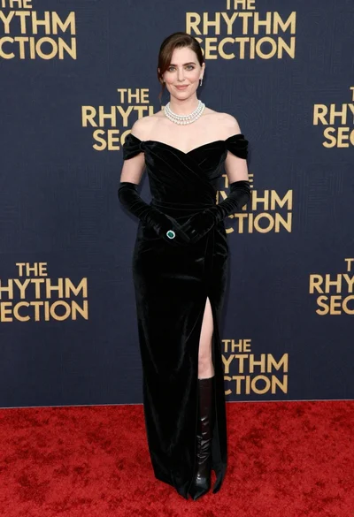 Glamorous woman in black gown posing on a red carpet premiere event