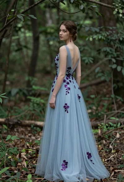 Young woman in light blue gown standing in a lush forest setting