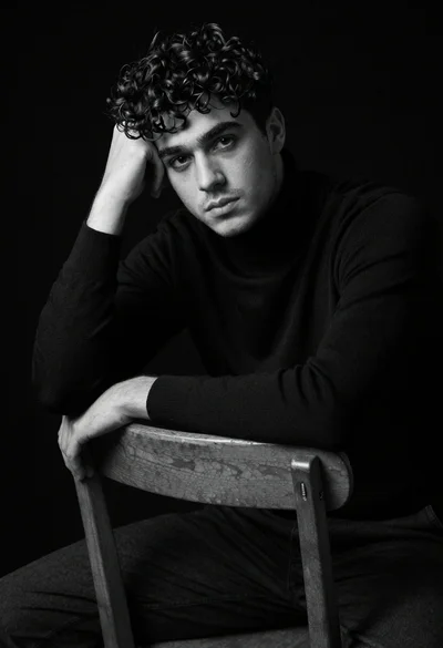 Medium shot portrait of young man in black turtleneck against void