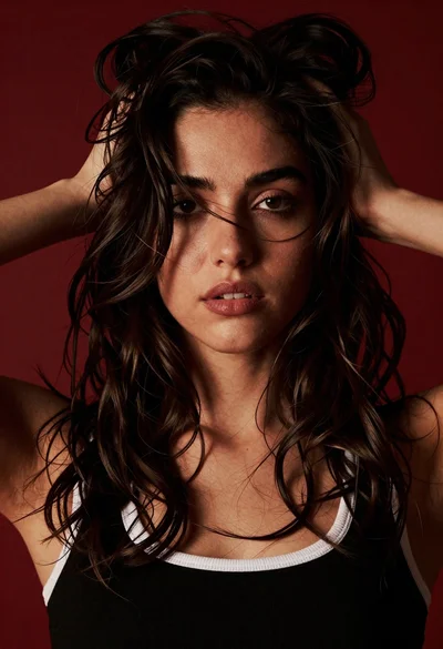 Dramatic close up portrait of young woman with dark wavy hair