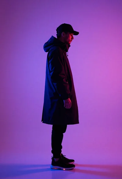 Person in dark streetwear against purple pink gradient background