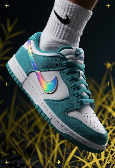 Close up shot of white and teal nike dunk low sneaker floating