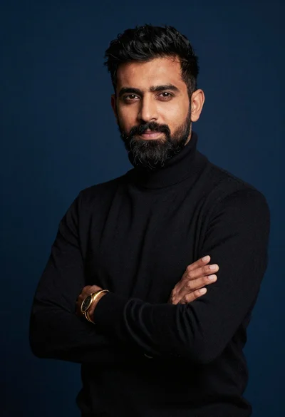 Studio portrait of man in black turtleneck against blue background