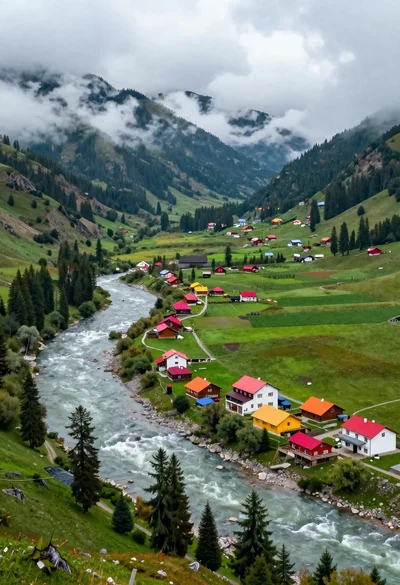Aerial view of lush mountain valley with colorful houses and winding river