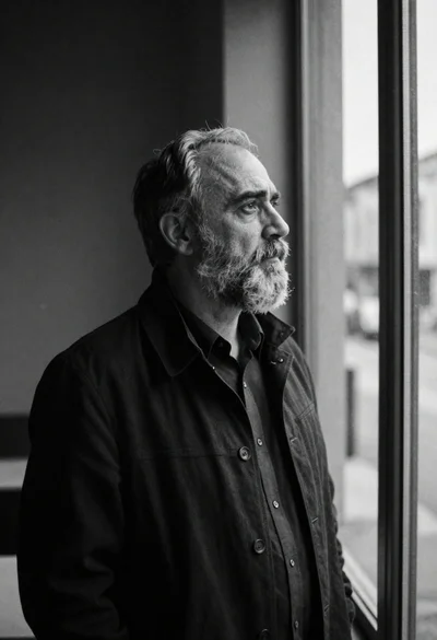Middleaged man looking out window in black and white