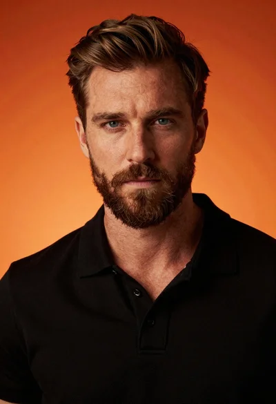 Handsome man with brown hair and beard in black polo shirt against
