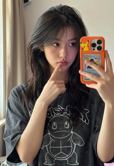 Young woman taking mirror selfie in oversized tshirt with pokemon accessories