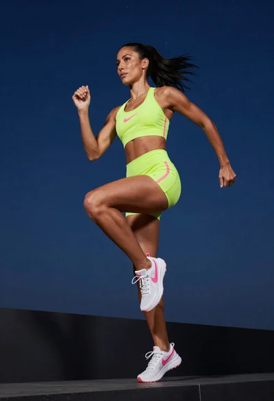 Fit woman in neon lime green athletic wear running mid stride