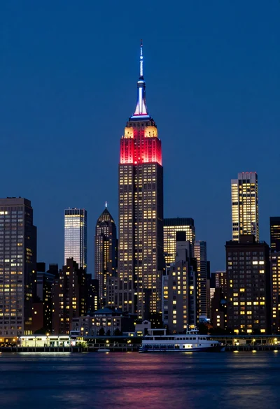 Low angle wide shot of manhattan skyline at night with illuminated empire