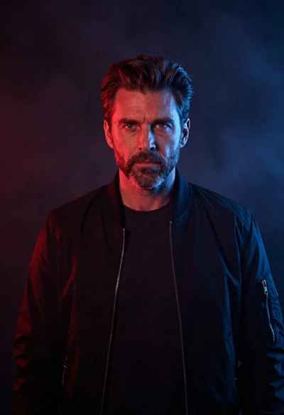 Cinematic portrait of mature man with brown hair and stubble in bomber