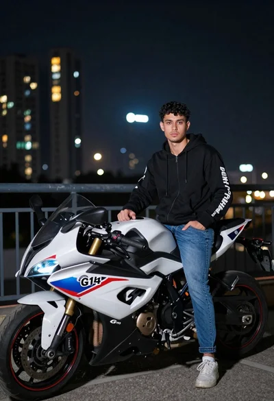 Young man with curly hair standing by motorcycle on balcony at night