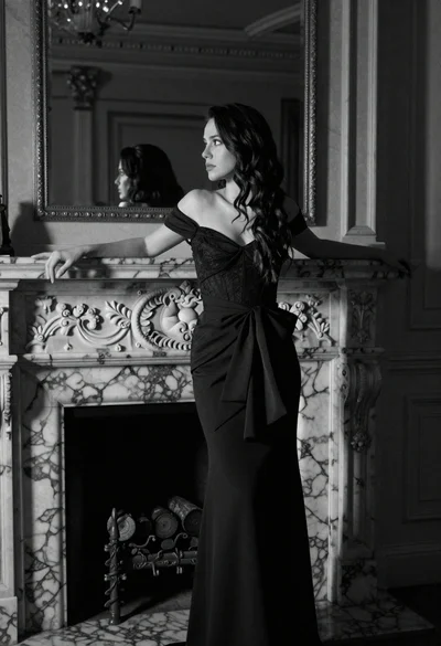 Woman leaning on ornate marble fireplace in dimly lit opulent room