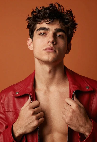 Handsome young man in red leather jacket looking up studio portrait