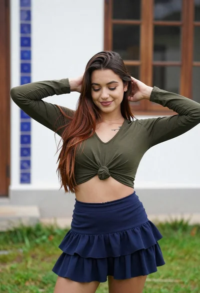 Young woman adjusting brown hair outdoors near blue tiled building wall