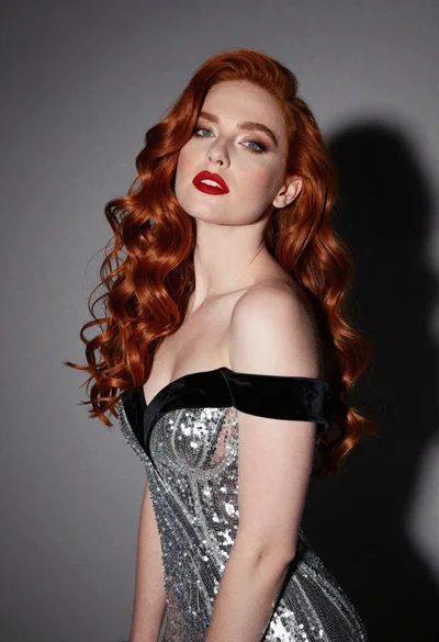 Glamorous portrait of woman with red hair in silver gown