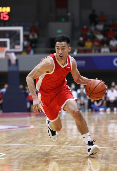Basketball player dribbling on an indoor hardwood court