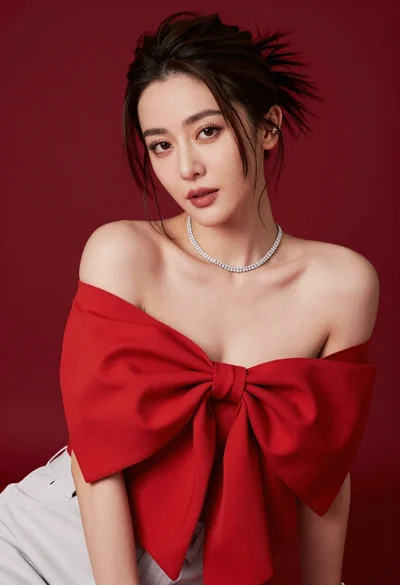 Confident woman in red off shoulder top against solid deep red studio